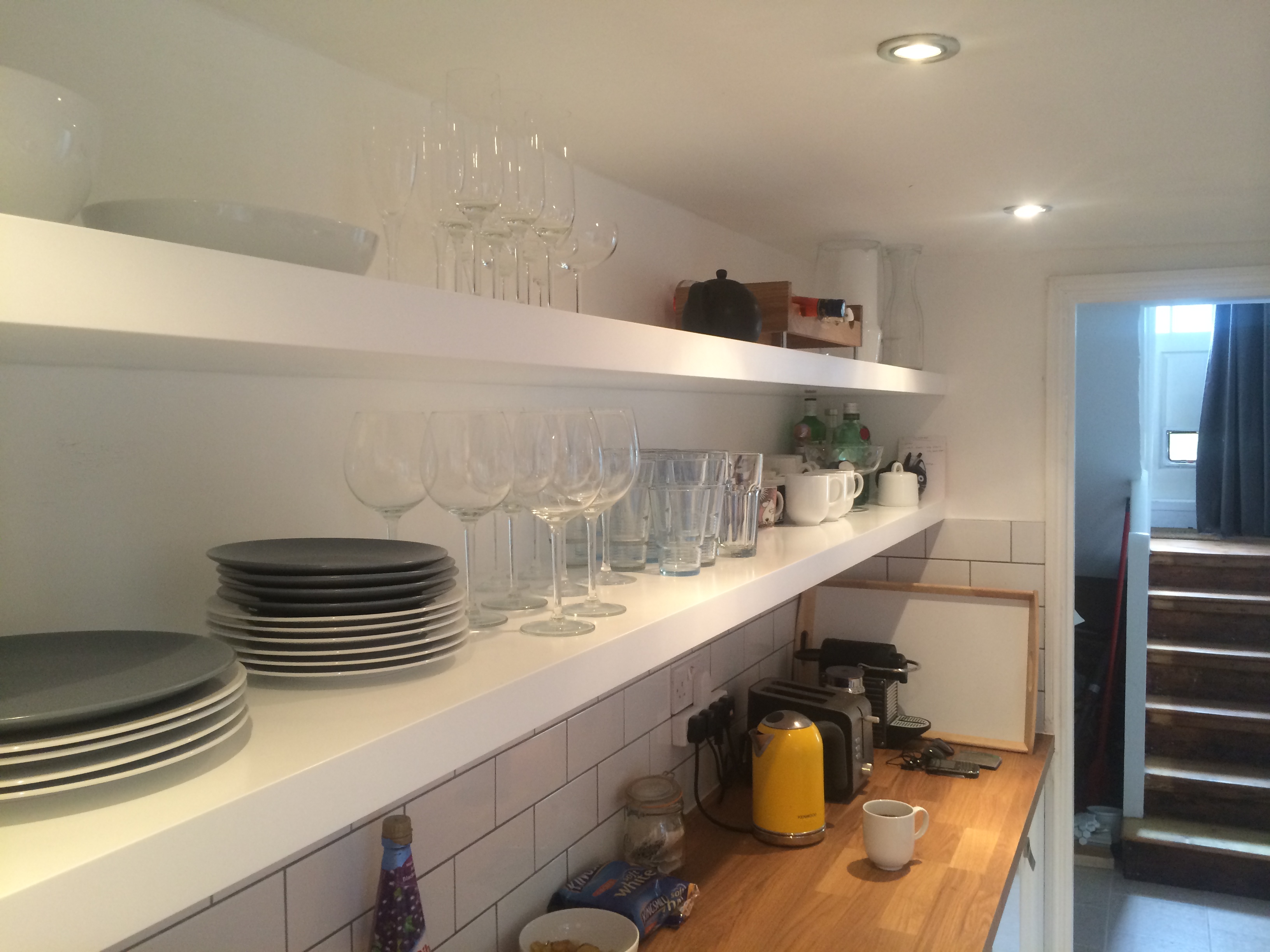white kitchen with floating shelves walnut bar
